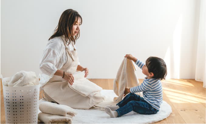 タオルを畳むお母さんと男の子