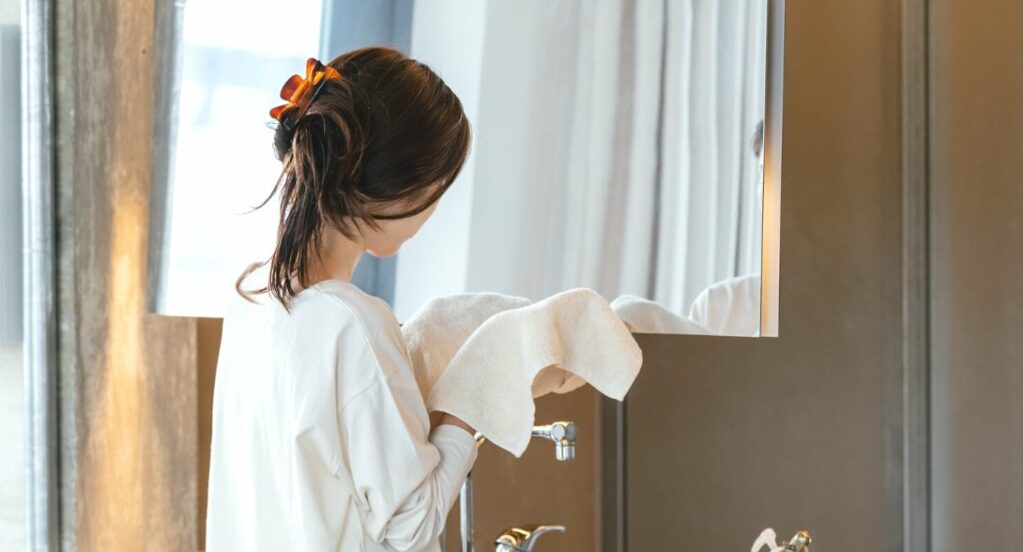 タオルで顔を拭く女性