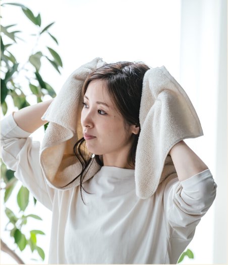 タオルで髪を拭く女性